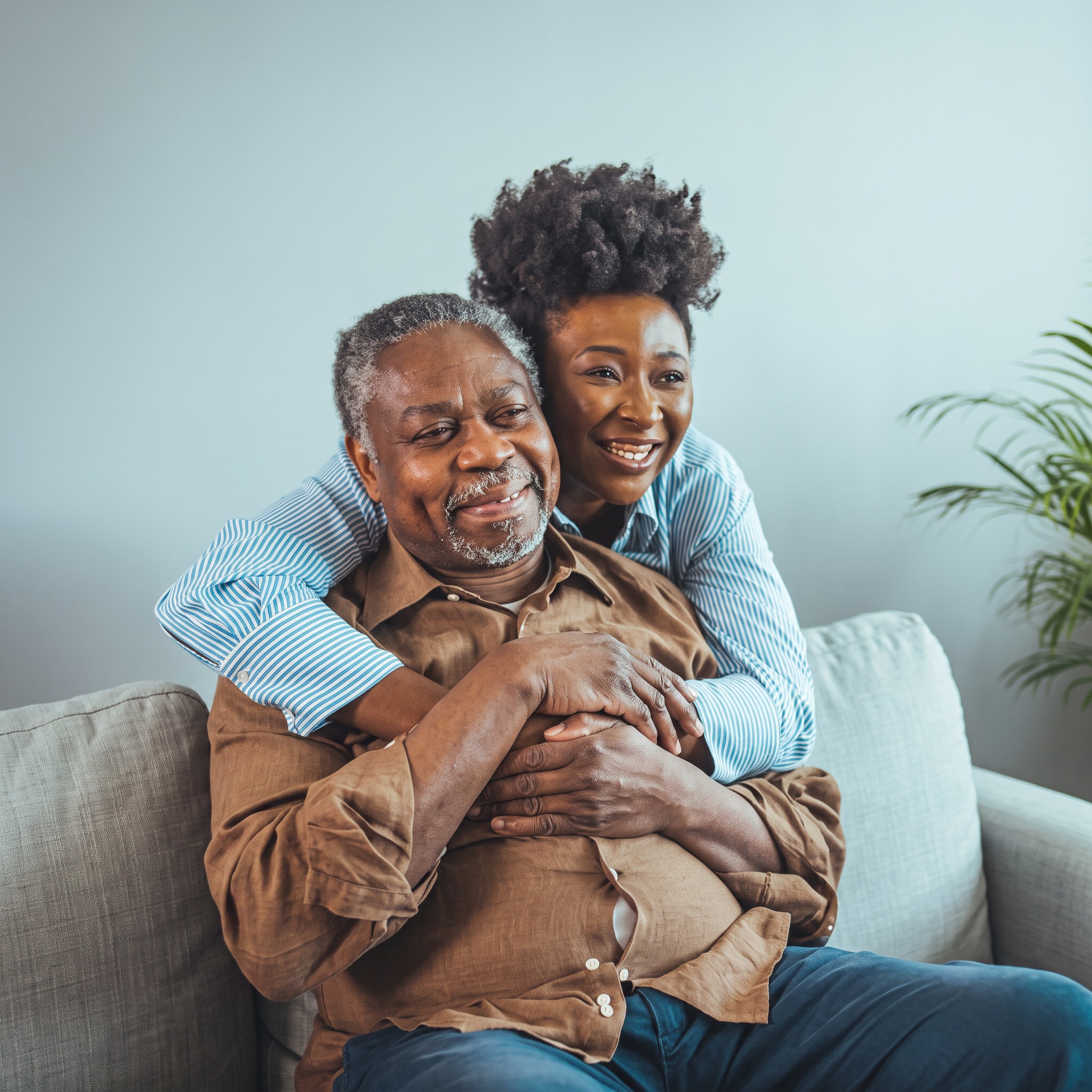 A Storge caregiver holding hands with a smiling older woman in her living room